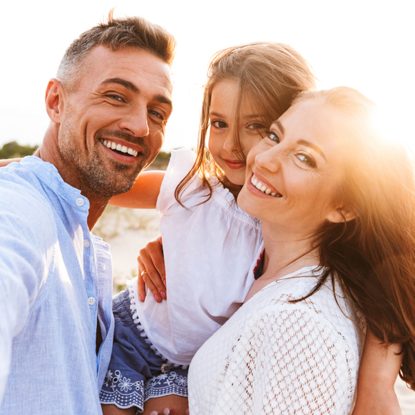 Prevention Family of 3 Smiling Outdoors